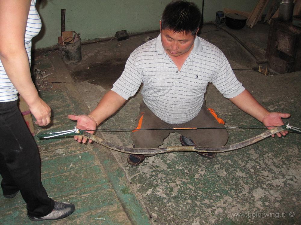 IMG_1677.JPG - Dulaankhaan (Mongolia), Boldbaatar mi mostra come si arma un arco mongolo: 3) si inserisce la corda nell'altra estremità dell'arco