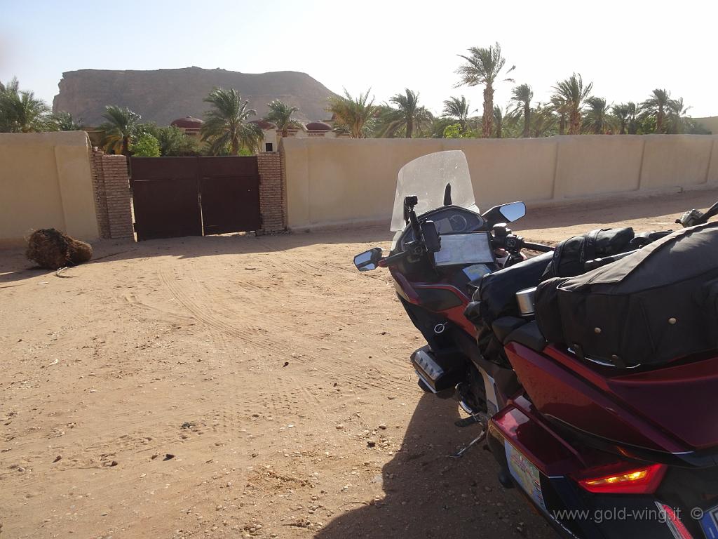 DSC00828.JPG - Individuo un cancello, ma è chiuso, senza citofono, e nessuno risponde alla mie grida o al clacson della moto. Si vede il Jebel Barkal dietro il recinto della Nubian Rest House di Karima
